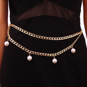 Close-up of double-layer gold waist chain with four pearls on black dress
