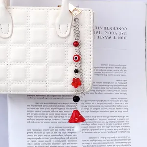 Detail of mushroom and evil eye charms on a stylish silver chain for handbags