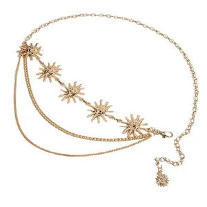 Detail van de gouden metalen lichaamsketting met drie lagen en zonnehangers