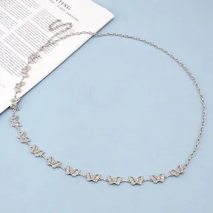 Close-up of silver butterfly waist chain with sparkling rhinestones on blue fabric