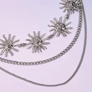 Detailweergave van de zilveren gelaagde lichaamsketting met lachende zon-hangers