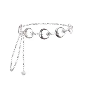 Chaîne de taille argentée avec breloques lune et étoile et détails de glands sur blanc