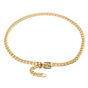 Close-up of golden metal Cuban chain belt with square buckle and geometric charms