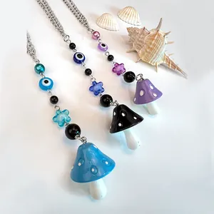 Detalle de colgantes de setas de colores y cuentas de mal de ojo en varios collares