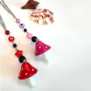 Detalle de llaveros de hongo hechos a mano con cuentas de colores y dijes de ojo turco