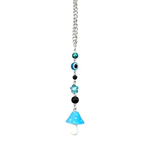 Détail du pendentif œil maléfique et champignon bleu avec chaîne en métal argenté