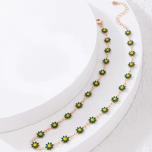 Adjustable gold chain necklace featuring multiple green daisy charms and lobster clasp
