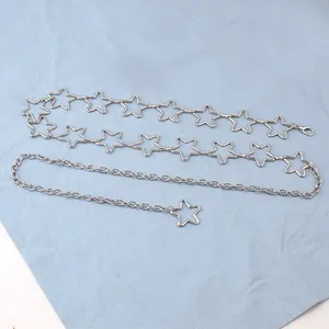 Macro detail of silver star waist chain with hollow pendants and lobster clasp