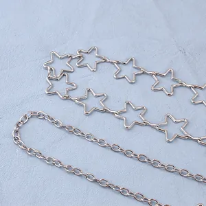 Close-up of polished silver star chain and dual-layer belt detail with metallic shine