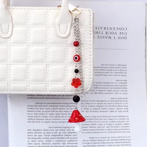 Détail d'un pendentif perlé avec œil protecteur et champignon sur un sac en cuir matelassé