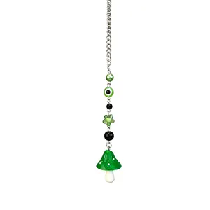 Détail de la chaîne perlée œil maléfique vert et pendentif champignon à pois
