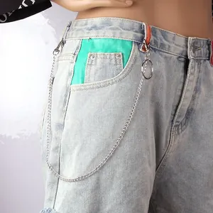 Macro detail of punk rock silver metal trousers chain with large ring on denim jeans