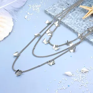 Macro shot of silver multi-layer butterfly chain accessories on a beach sand background