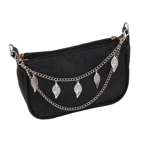 Detail of black PU leather bag with silver double chain and hollow leaf charms