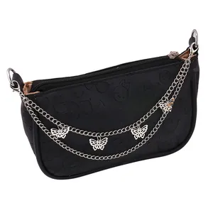 Close-up of a black PU leather bag featuring embossed cartoon motifs and butterfly chains