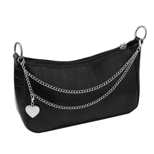 Detail of black faux crocodile skin texture and silver chain with heart pendant