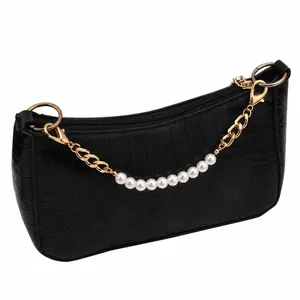 Close-up of black crocodile pattern handbag with gold chain and 10mm white pearls