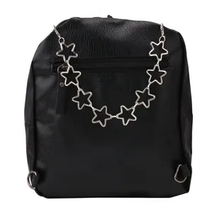 Macro shot of silver star metal chain and zip pocket on black lychee leather backpack