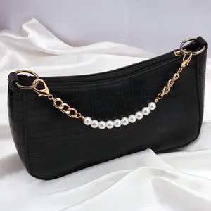 Bolso de mano negro con patrón de cocodrilo, cadena dorada y correa de perlas falsas