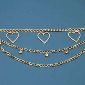 Detailed close-up of triple-layered gold waist chain with crystal-studded heart pendants