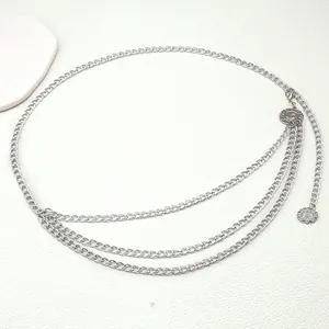 Detail view of multi-layer silver waist chain with starburst pendants on light background