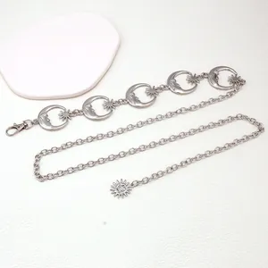 Detail of vintage silver metal chain belt featuring moon and star hollow charms