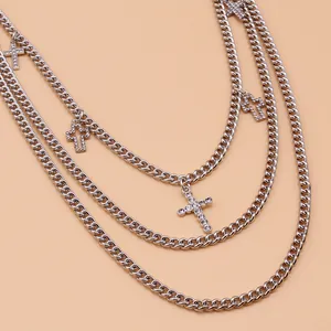 Gros plan de chaînes punk argentées à trois couches avec pendentifs croix en strass