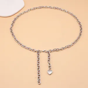 Detail of silver link waist chain with polished heart pendant on a neutral background