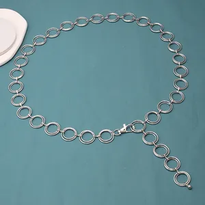 Détail d'une ceinture chaîne multicouche en métal argenté avec anneaux et fermoir mousqueton