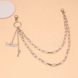 Detail view of a multi-layer silver pants chain with heart wing and key metal pendants