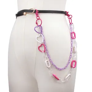 Detail of double-layer acrylic and metal waist chain with heart rings on black belt