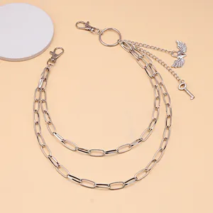 Detail of silver double-layered hip chain featuring heart wing and key charms