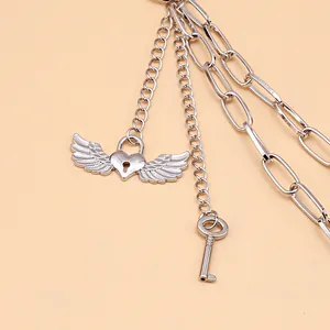 Detail of silver heart lock and wing charms on a multi-layer punk style metal body chain