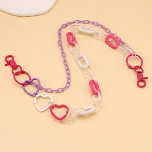 Detail of colorful acrylic chain with purple links and heart clips for pants and bags