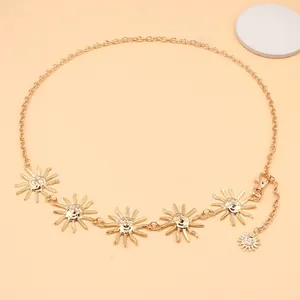 Detail of gold metal waist chain featuring sun smiley face charms and lobster clasp