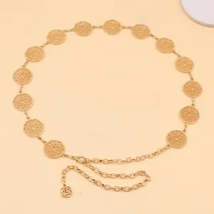Detail of gold metal waist chain featuring hollow floral links and small rose pendant