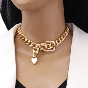 Chunky gold chain choker featuring a belt buckle clasp and heart pendant on a model