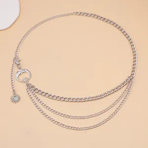 Macro detail of silver layered waist chain with crescent moon and sun metal charms