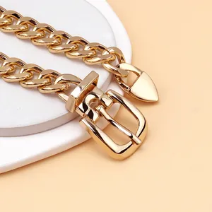 Detail of the golden chunky chain necklace featuring a classic buckle clasp close-up