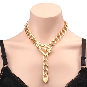 Detail of chunky gold chain necklace with belt buckle clasp and heart pendant