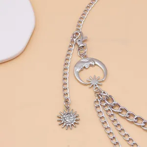 Close-up of silver multilayer metal chain with sun and crescent moon pendants