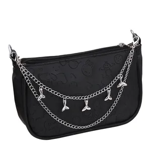 Detail of black leather bag with embossed cartoon patterns and silver whale tail chains