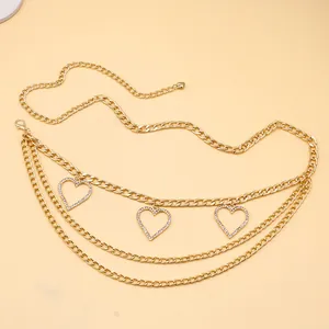 Détail de la chaîne de taille dorée avec pendentifs cœurs scintillants et fermoir mousqueton