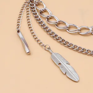 Detail of silver layered chain featuring intricate feather and metal bar pendants