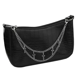 Detail of black crocodile texture crossbody bag with silver chains and gothic crosses