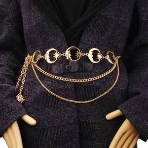 Gold celestial body chain with sun and crescent moon charms on purple fabric
