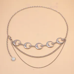 Silver multi-layer body chain featuring crescent moon and sun face charms on pink background