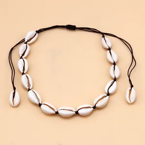 Close-up of handmade cowrie shell choker with adjustable black braided cord detailing