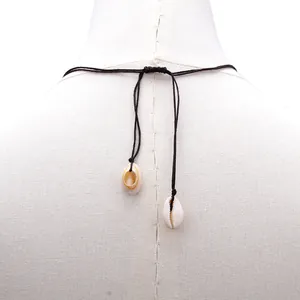 Detail of adjustable black cord beach necklace with hanging white natural cowrie shells
