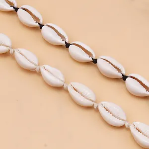 Detail of natural cowrie shell necklaces with black and beige braided cord knotting